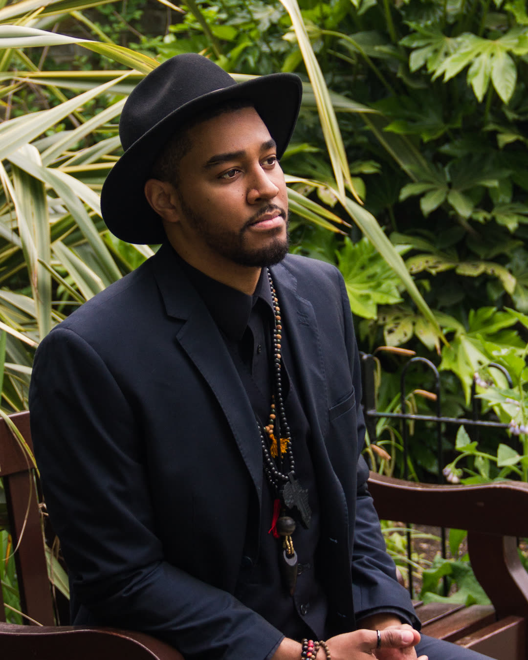 Kwame seated, relaxed, surrounded by greenery