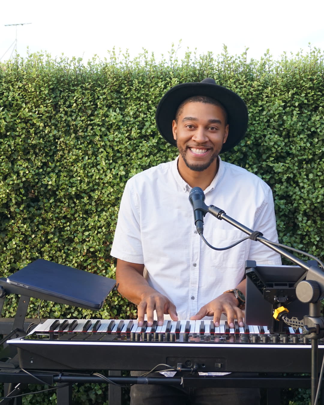 Kwame at the piano, smiling mid-performance